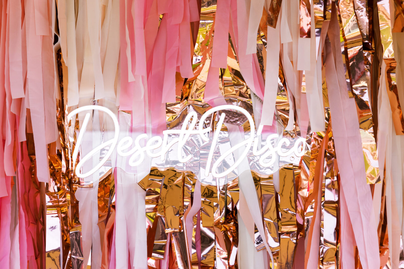 Neon sign surrounded by colorful streamers.