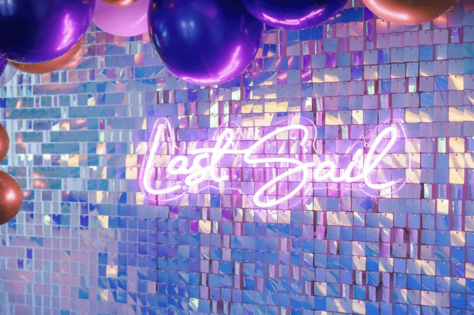 Purple metallic balloons over iridescent sequin wall